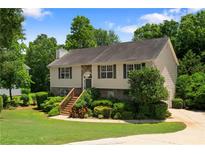 Charming two-story home featuring a landscaped front yard, stone accents, and inviting entry stairs at 90 Cypress Dr, Covington, GA 30016