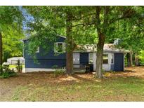 Charming blue house exterior with a well-maintained lawn and mature trees in a peaceful setting at 35 Pawn Dr, Carrollton, GA 30116