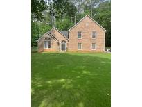Charming brick two-story home with arched window and lush green lawn at 8035 Canter Ln, Alpharetta, GA 30009