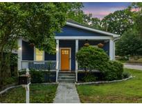 Charming blue bungalow with a welcoming yellow front door and well-manicured landscaping at 1211 Mortimer Se Pl, Atlanta, GA 30317
