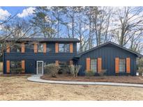 Charming two-story home featuring a dark blue exterior and decorative wooden shutters at 5427 Fieldgreen Dr, Stone Mountain, GA 30088