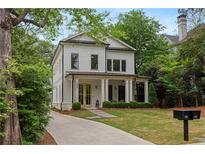 Charming two-story home with white siding, black trim, manicured landscaping, and a welcoming front porch at 357 Mell Ave, Atlanta, GA 30307