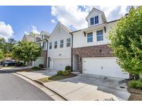 Charming townhome exterior showcasing a blend of brick and siding, complemented by well-manicured landscaping at 408 Niles Ct, Marietta, GA 30060