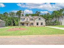 Two-story home featuring brick and siding, well-manicured lawn, and a welcoming front porch at 600 Sidney Ct, Stockbridge, GA 30281