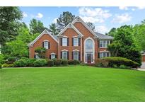 Beautiful two-story brick home with a manicured lawn and lush landscaping at 4004 Charrwood Trce, Marietta, GA 30062