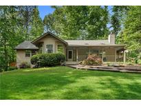 Charming single-Gathering home featuring lush green lawn, mature trees and manicured landscaping at 1920 Jett Ridge Rd, Cumming, GA 30041