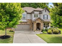 Charming two-story home with stone accents, attached garage, and a well-manicured front yard at 4779 Bogan Meadows Dr, Buford, GA 30519