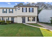 Charming townhome with tidy lawn, sidewalk, and traditional architectural details at 3589 Hopkins Ct, Powder Springs, GA 30127
