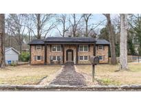 Charming brick home featuring a symmetrical facade, covered porch with columns, and landscaped front yard at 1343 Renee Dr, Decatur, GA 30035
