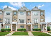 Charming multi-story townhouse with stone and siding exterior, complemented by well-manicured landscaping at 5529 Festival Ave, Fairburn, GA 30213
