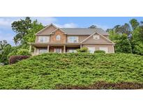 Charming two-story home features a stone facade, covered porch, and lush landscaping at 6086 Willowpond Ct, Douglasville, GA 30135