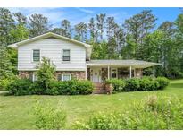 Charming home with a manicured lawn, covered porch and brick and stone accents at 757 Tall Deer Dr, Fairburn, GA 30213