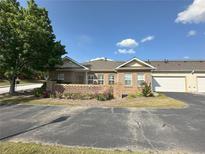 Charming single-story brick townhome with attached garage and meticulously manicured landscaping at 125 Villa Park Cir, Stone Mountain, GA 30087