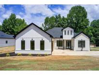 Beautiful modern farmhouse with white siding, black trim, and a well-manicured lawn at 532 Rockbridge Rd, Lilburn, GA 30047