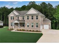 Stunning two-story brick home with attached two-car garage, well-manicured lawn and welcoming front porch at 297 Delta Dr, Mcdonough, GA 30252