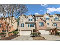 Inviting townhouse with a two-car garage, a combination of brick and siding, and a neatly manicured front yard at 506 Glen Ivy # 5, Marietta, GA 30062