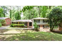 Charming home with brick and white siding, mature trees, and landscaped front yard offers great curb appeal at 2620 Clairmont Rd, Atlanta, GA 30329