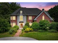 Charming brick home with stone accents, lush landscaping, and a welcoming entryway at 11569 Finley St, Suwanee, GA 30024