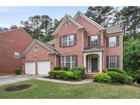 Charming two-story brick home featuring a well-manicured lawn and a two-car garage at 3962 Coventry Park Ln, Peachtree Corners, GA 30096