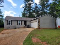 Cozy single-story home with a garage, stone accents, and a well-maintained lawn at 1094 Reynolds Ct, Morrow, GA 30260