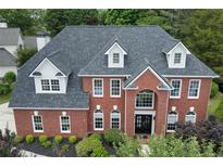 Stately brick home featuring a symmetrical facade, dormer windows and manicured landscaping at 1820 Hunters Moon Dr, Alpharetta, GA 30005