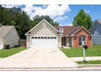 Charming home showcasing a blend of siding and brick accents, complimented by a well-manicured front yard at 4016 Meadow Glen Way, Fairburn, GA 30213