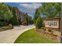 Welcoming entrance to Sterling of Dunwoody, featuring lush landscaping and well-maintained brick signage at 2300 Peachford Rd # 3411, Dunwoody, GA 30338