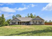 Charming single-story home with a well-maintained lawn and inviting front porch on a sunny day at 569 Lovell Rd, Temple, GA 30179