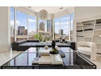 Modern living room featuring a large window with stunning city views and contemporary decor at 285 Centennial Olympic Park Nw Dr # Ph2-7, Atlanta, GA 30313