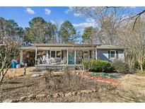 Charming single-story home featuring a cozy front porch with chairs and well-maintained landscaping at 315 Charlotte Blvd, Stockbridge, GA 30281