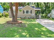 Charming bungalow with a well-maintained front yard, mature trees, and inviting entrance at 2923 Akron St, East Point, GA 30344