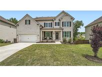 Charming two-story home with white brick, dark shutters, and a well-manicured front yard at 7820 Bristol Valley Dr, Cumming, GA 30028