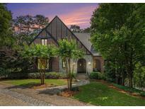 Beautiful brick Tudor-style home with landscaped front yard and stone walkway to the arched front door at 927 Berkshire Ne Rd, Atlanta, GA 30324