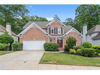 Charming two-story brick home with a well-manicured lawn and a two-car garage at 1010 Graystone Xing, Alpharetta, GA 30005
