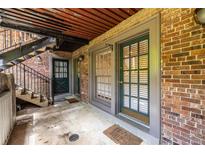 Apartment entrance featuring brick walls, an exterior staircase, and dark green doors with large windows at 3091 Colonial Way # I2, Atlanta, GA 30341