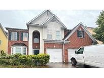Two-story brick home with a two-car garage and manicured landscaping at 3525 Park Hill Cir, Loganville, GA 30052
