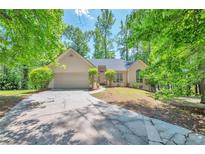 Charming single-story home featuring a well-maintained lawn, mature trees, and an attached two-car garage at 616 Lone Oak Ct, Lithonia, GA 30058
