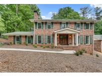 Charming brick home with green shutters, a covered front porch, and a well-manicured lawn at 2592 River Oak Dr, Decatur, GA 30033