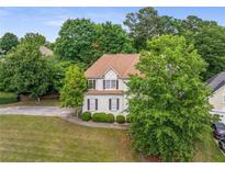 Charming two-story home featuring a well-manicured front yard and a classic design with beautiful landscaping at 600 Oakmont Hl, Duluth, GA 30097