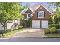 Beautiful brick home featuring a two-car garage, manicured landscaping, and mature trees at 1064 Saint James Xing, Brookhaven, GA 30319
