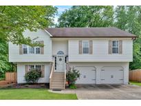 Charming two-story home featuring a well-maintained front yard and an attached two-car garage at 4053 Five Oaks Ct, Powder Springs, GA 30127