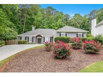 Charming one-story home with landscaped front yard and blooming flowers, offering great curb appeal at 703 Kirkwood Cir, Woodstock, GA 30189