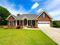 Beautiful brick home with a well-manicured lawn and a two-car garage, perfect for a Gathering at 3426 Olivia Grace Way, Dacula, GA 30019