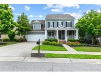 Charming two-story home with a well-manicured lawn, flower beds, and attached two-car garage at 6069 Queens River Dr, Mableton, GA 30126