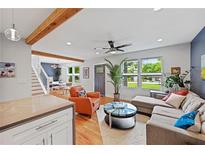 Open-concept living room featuring hardwood floors, a ceiling fan, natural light, and stairs to the second floor at 670 Parker Ave, Decatur, GA 30032