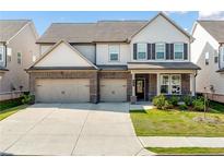 Beautiful two-story home with a brick and siding exterior, a spacious driveway and a well-manicured lawn at 517 Hyde Ridge Trl, Loganville, GA 30052