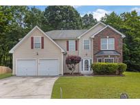 Charming two-story home featuring a blend of vinyl siding and brick accents, complemented by a well-manicured front yard at 6032 Trotters Cir, Fairburn, GA 30213