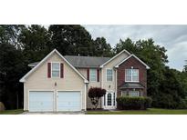 Charming two-story home featuring brick and siding, a two-car garage, and a well-manicured front lawn at 6032 Trotters Cir, Fairburn, GA 30213