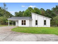 Charming single-story home with modern architectural details, grassy front yard, and convenient carport at 1070 Kirkland Rd, Covington, GA 30016