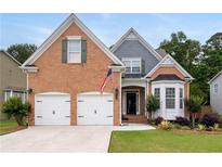 Charming brick home with well-manicured lawn, two-car garage, and inviting front porch at 3480 Arbroath Dr, Douglasville, GA 30135